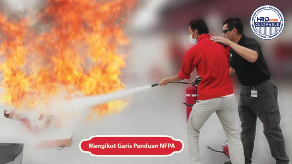 Dua individu semasa kursus latihan memadam kebakaran, memadamkan kebakaran terkawal