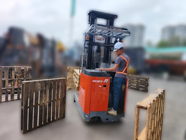 A trainee operates an orange Toyota Geneo-R during a professional reach truck training session in a warehouse.