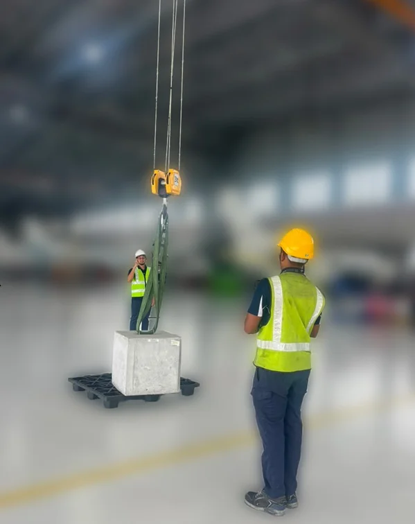 Workers in safety gear practicing hand signals and lifting techniques during an Overhead Crane training course
